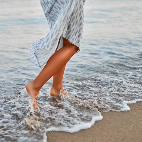 a person waling in the water on a beach a person waling in the water on a beach