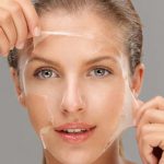 Woman pealing a face mask off Woman pealing a face mask off